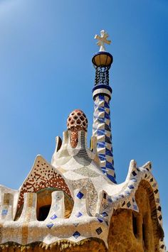 the top of a building with a light on it's side and a blue sky in the background