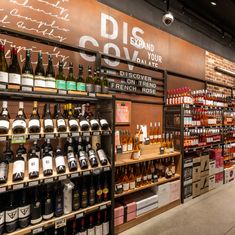 bottles of wine are lined up on shelves in a liquor store that is stocked with various types of wines