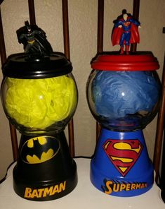 two toy batman and superman gummy balls dispensers sitting on a table