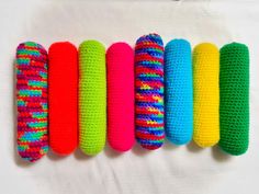 six crocheted hair brushes lined up in a row on a white surface,