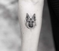 a black and white photo of a dog's head on the left inner arm