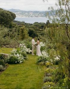 a bride and groom standing in the middle of a garden