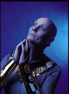 a man with his hands on his face holding a golden object in front of him