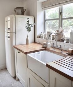 a kitchen with a sink, refrigerator and window