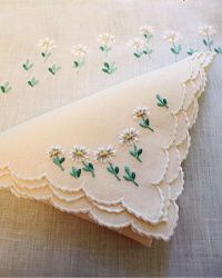 two pieces of cloth with embroidered flowers on them