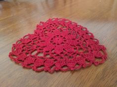 a red doily sitting on top of a wooden floor