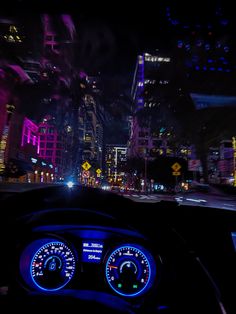 the dashboard of a car at night with city lights in the background