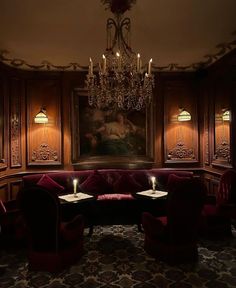 a room with two red couches and a chandelier