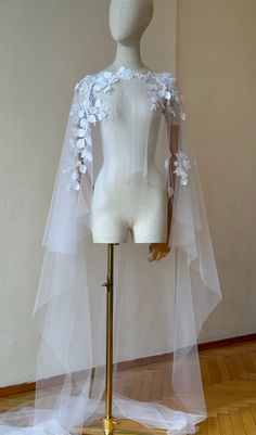 a mannequin wearing a white wedding dress and veil