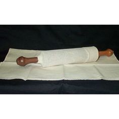 a roll of paper with a wooden handle sitting on top of a cloth covered table