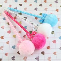 three pom - poms hanging from a hook on a polka dot tablecloth