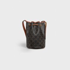 a brown and black bucket bag on a white background with the handle down to it's side