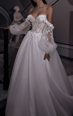 a woman in a white wedding dress standing next to a stair case with her hands on her hips