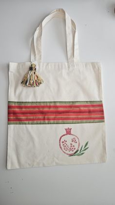 a white bag with a pomegranate on it