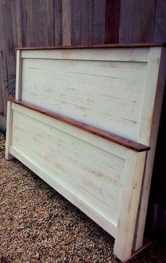 a wooden bench sitting in front of a wall with wood slats on the sides