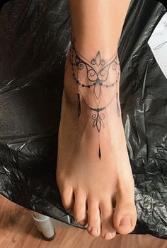 a woman's foot with a tatoo on top of it and a black background