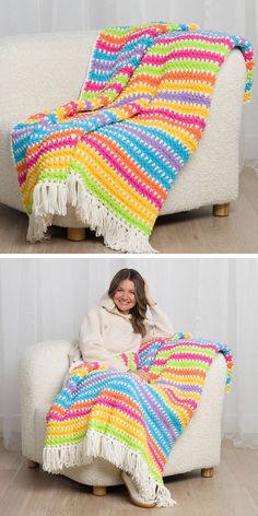 a woman sitting on a couch under a rainbow blanket