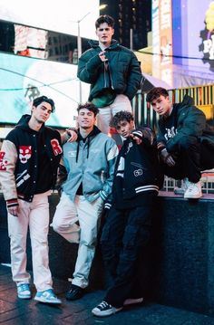 four young men posing for a photo in the city