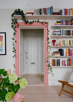 a room with bookshelves and flowers on the wall