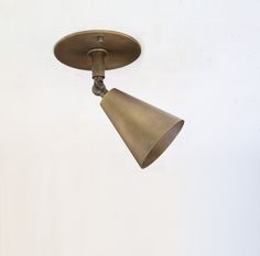 an overhead light fixture with a white wall in the background and no one around it