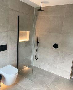 a bathroom with a toilet, shower and glass door in it's center area