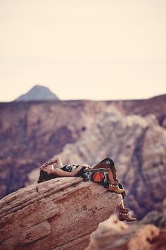 a woman laying on top of a wooden log in the desert