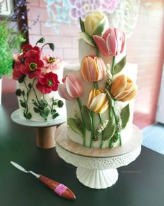 two cakes decorated with flowers on top of a table