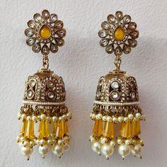 Embrace the allure of tradition with our Yellow Crystal and Pearl Suspended Kundan Jhumka Set--a premium ensemble of exquisite Indian craftsmanship. These Bollywood-inspired earrings effortlessly blend Pakistani elegance with a touch of regality. Adorned with radiant yellow crystals and delicate pearls, the intricate Kundan work lends a timeless charm to this jhumka set. Elevate your style and make a statement with these resplendent earrings that capture the essence of cultural opulence. Materials: Metal Alloy, Crystal, Pearl, Kundan ❋❋ Shipping Methods ❋❋ Standard Delivery - Take up to 8-14 business days (Worldwide). ❋❋ Please be aware that the colors, shades, and texture shown may exhibit minor variations compared to the actual product due to limitations in digital imaging. We kindly ask Festival Celebration Jhumkas Drop Earrings, Festive Jhumkas For Festivals, Festive Drop Earrings For Festivals, Festival Jhumkas Drop Earrings, Traditional Jhumkas With Matching Earrings For Eid, Heavy Drop Jhumkas For Diwali, Bollywood Style Jhumkas For Celebration With Intricate Design, Heavy Jhumkas For Diwali, Bollywood Style Festive Jhumkas Dangle Earrings