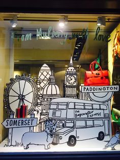 a window display with paper cutouts of london and the big ben clock tower in it