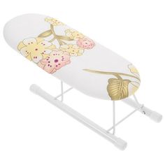 a white ironing board with flowers and leaves painted on the side, sitting on a stand