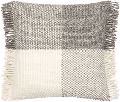 a gray and white pillow with fringes on the front, in two different colors