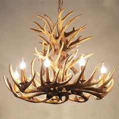 a chandelier with deer antlers hanging from it's sides and four lights on each side