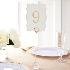 there is a table with plates and place cards on it that have the number nine on them