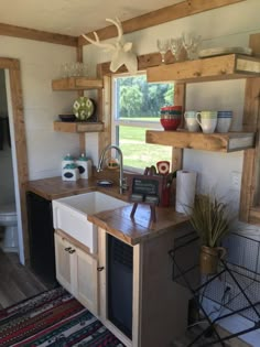 a kitchen area with sink, stove and shelves