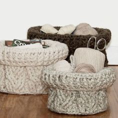 two knitted baskets sitting on top of a wooden floor