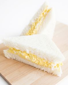 two slices of cake sitting on top of a wooden cutting board next to each other