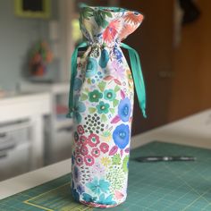 a flowered bag sitting on top of a cutting board next to a knife and scissors