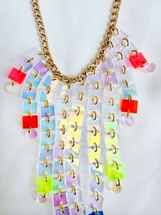 Pride is all about being loud and fun, and this necklace is that and MORE! Length: 17" - 20" Material: Gold Plated Aluminum Chain; Transparent Neon Pink, Rust, Acid, Blue, Purple, & Iridescent Acrylic Handmade in NYC, ready to ship! We are a small team: processing takes between 1-10 business days, depending on the number of orders. Thank you for your patience! Shipping and Returns policy All sales items are final sale Have questions/need help? We're here for you! help@islynyc.com or reach out in Handmade Bold Jewelry For Party, Unique Multicolor Necklaces, Handmade Multicolor Chain Necklace For Party, Unique White Necklaces For Party, Multicolor Chain Jewelry, Unique Multicolor Chain Jewelry, Unique White Necklace For Party, Fusion Multicolor Party Necklaces, Multicolor Fusion Necklaces For Party