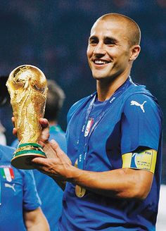 a man holding a soccer trophy in his hands