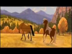 two horses are standing in the grass near mountains