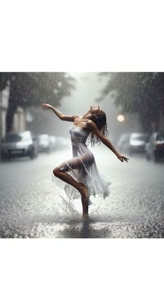 a woman is dancing in the rain with her arms spread out and legs bent forward