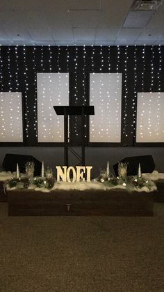 a room with lights and decorations on the wall, including a sign that says noel