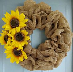 a burlock wreath with three sunflowers on the front door, ready to be hung