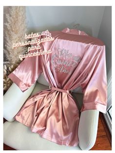 "Get ready for your Mis Quince Años celebration in style with our Quinceañera Satin Robes!  Crafted from soft and silky high-quality satin, these robes are designed to make you feel like a princess on your special day. With different options for text color and designs on the back side, you can customize your robe to match your unique style and personality. Not only are these robes perfect for getting ready, but they're also ideal for Instagram and Pinterest photos. Order yours Mis Quince robe today and step into your special day with elegance and grace!  Gold rhinestone tiara, ring dish, and jewelry case are photography props; they are not included in the purchase. S I Z E S &. M E A S U R E M E N T S (All measurements are approximate.) One Size (2-14): Bust: 48\" Hips: 52\" Length: 36\" P Rhinestone Tiara, Silk Robe, Custom Glitter, Pinterest Photos, Quince, Womens Robes, Sweet Sixteen, Dusty Pink, Quinceanera