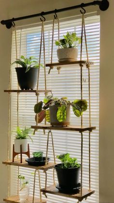 the hanging planter is made out of wood and has several plants in pots on it