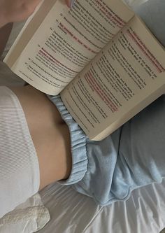 a person laying in bed reading a book