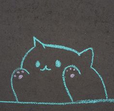 a drawing of a cat on the ground with blue chalk crayons next to it