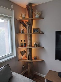 a living room filled with furniture next to a flat screen tv on top of a wooden shelf