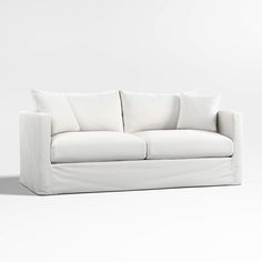 a white couch sitting on top of a white floor