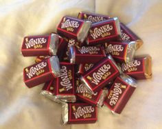 a pile of chocolate bars sitting on top of a white bed sheet with the word wokie's written on them